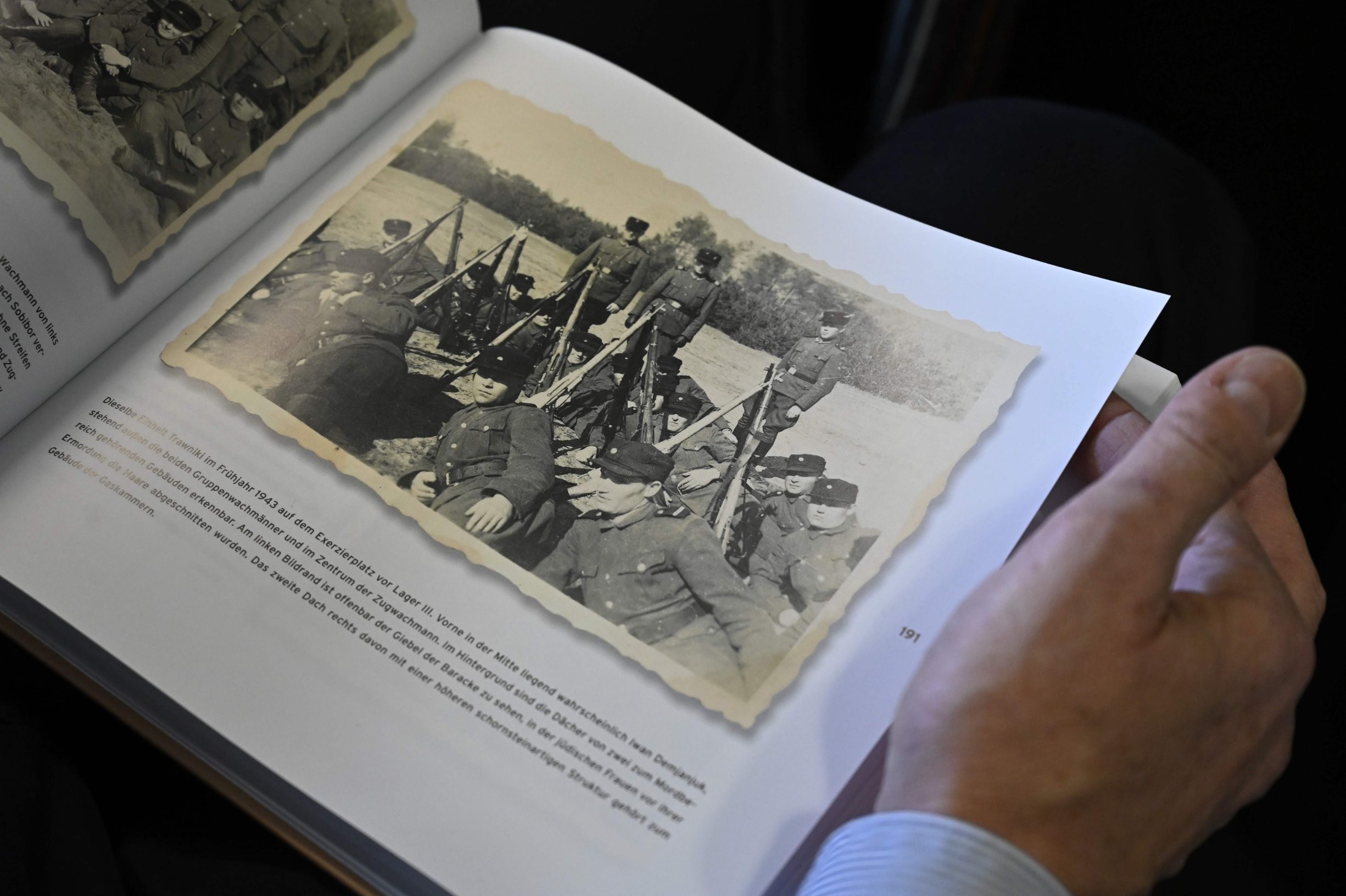 A journalist looks at a catalogue prior to a press conference to unveil newly discovered photos from Sobibor Nazi death camp on January 28, 2020 in Berlin. - A Berlin museum said on January 20, 2020 that it had unpublished photographs showing former guard John Demjanjuk at the Sobibor extermination camp, where he has denied ever having been. (Photo by Tobias SCHWARZ / AFP)